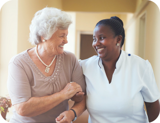Smiling home caregiver and senior woman walking together